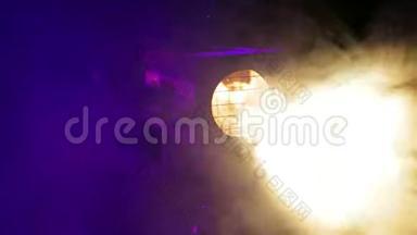 舞台上一阵烟雾中旋转的舞台轮廓聚光灯的致盲光束
